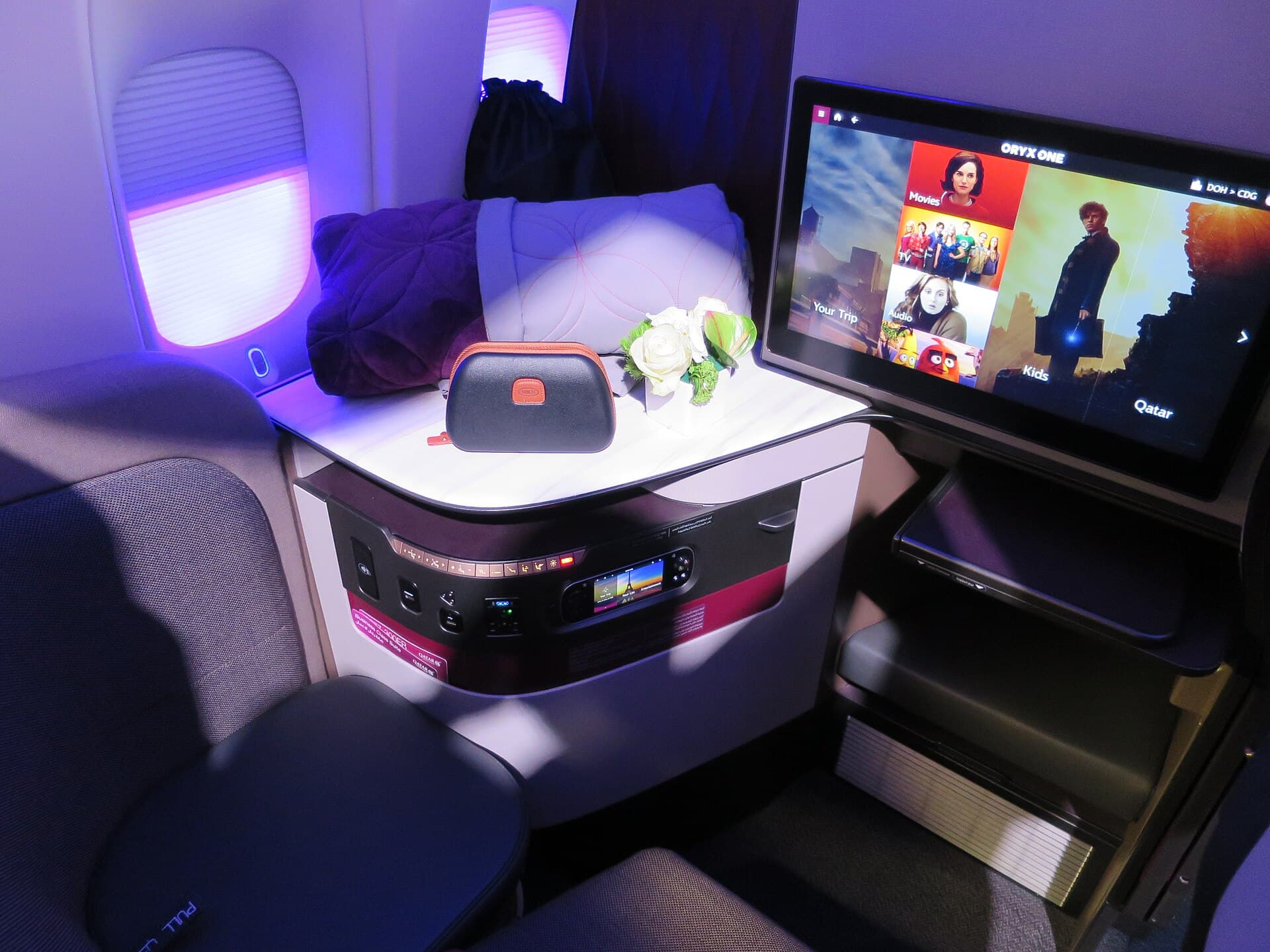 Qatar Airways Qsuite business class seat with lie-flat bed and privacy door.